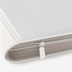 Close-up of the zipper pull and leather edge stitching on a white Pokemon toploader binder