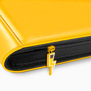 Close-up of lightning-bolt zipper pull on yellow Pokemon toploader binder with leather stitching