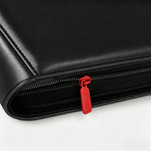 Close-up of a red zipper pull on a black leather card binder
