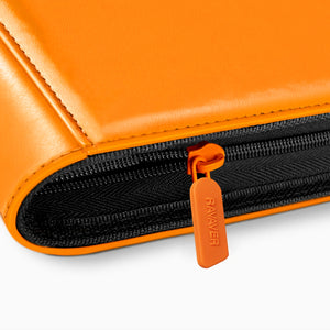 Close-up of the orange zipper pull and leather edge stitching on a Charizard Pokemon card binder
