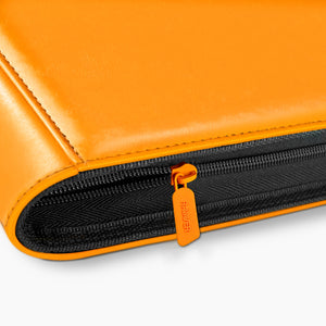 Close-up of the orange zipper pull and black zip tape running the edge of an orange Charizard card binder
