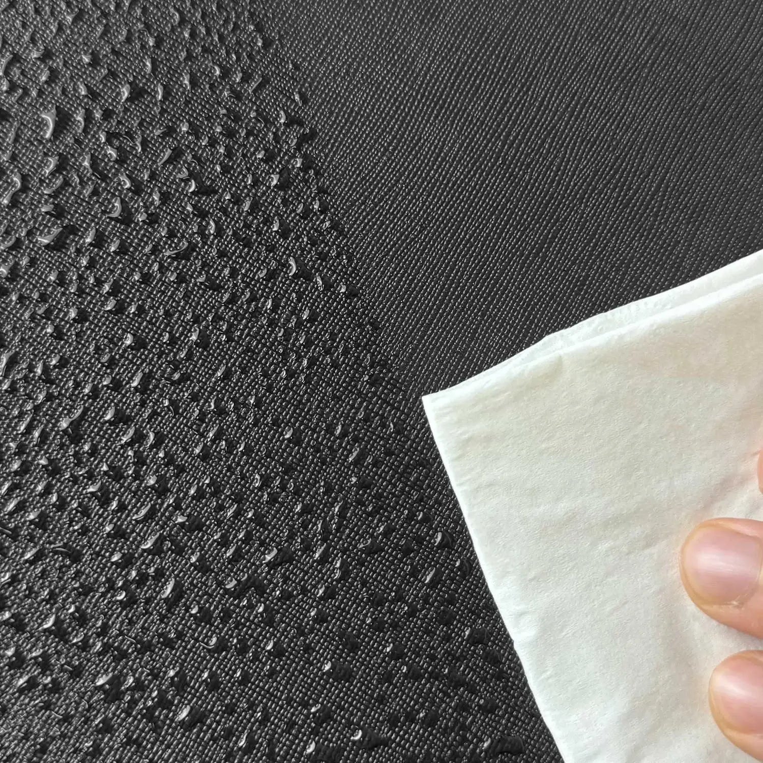 Water droplets beading on the water-resistant black PU leather surface of a Pokemon toploader binder