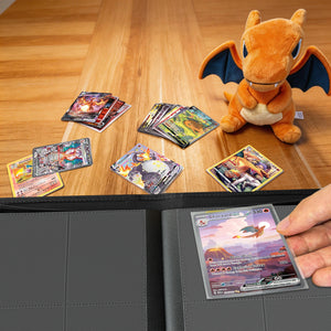 Orange Charizard 4-pocket Pokemon card binder on a table beside scattered holographic Charizard cards