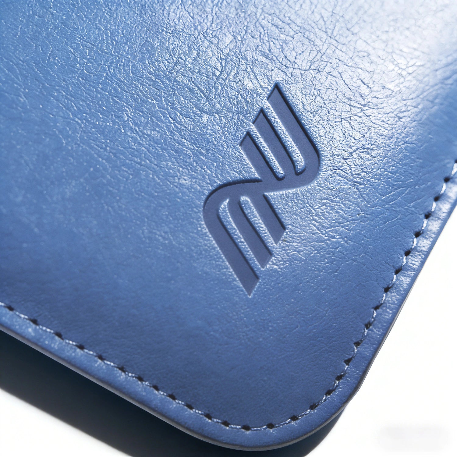 Close-up of the embossed logo and stitching on a blue leather Pokemon toploader binder corner