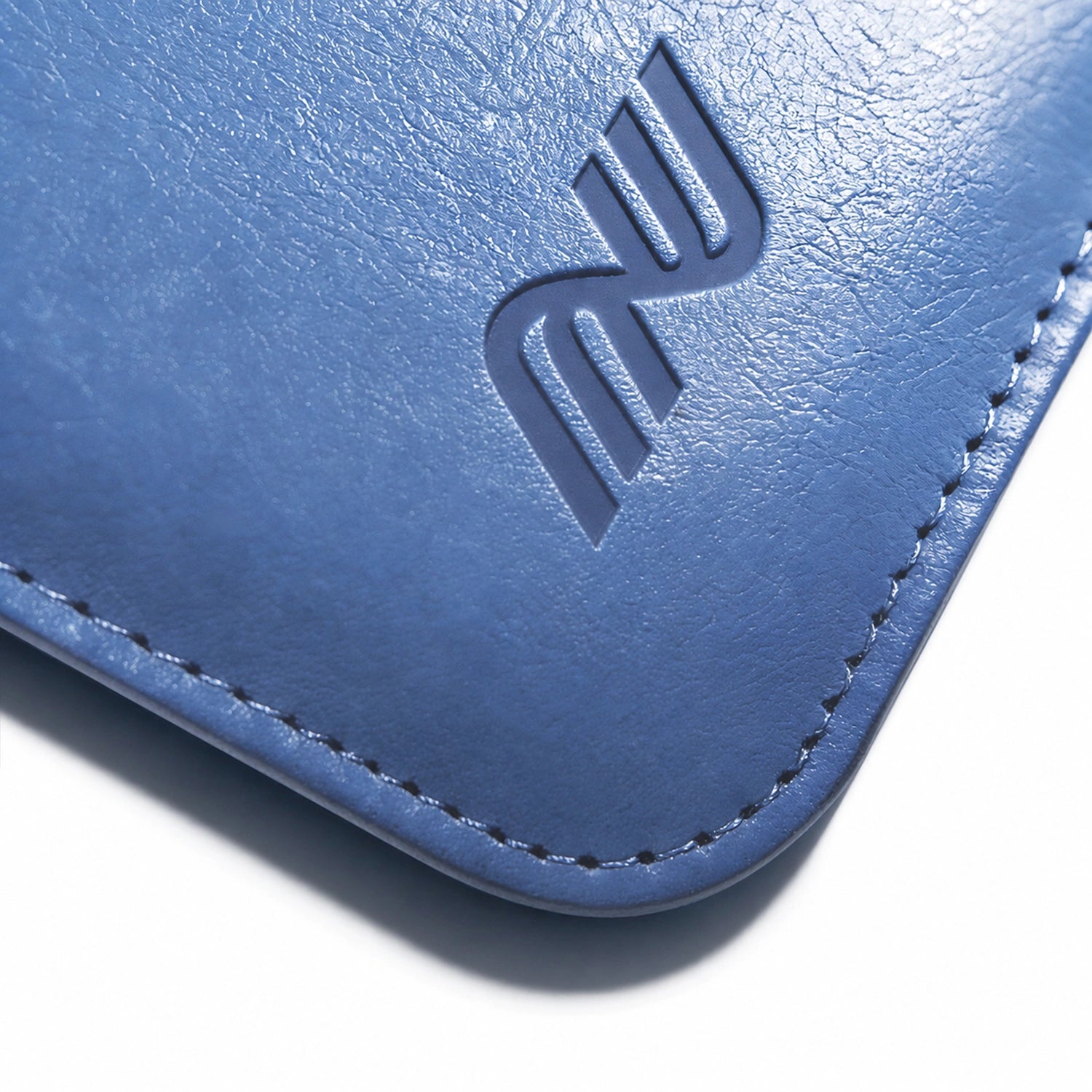 Close-up of the embossed logo and stitching on a blue leather Pokemon card binder corner
