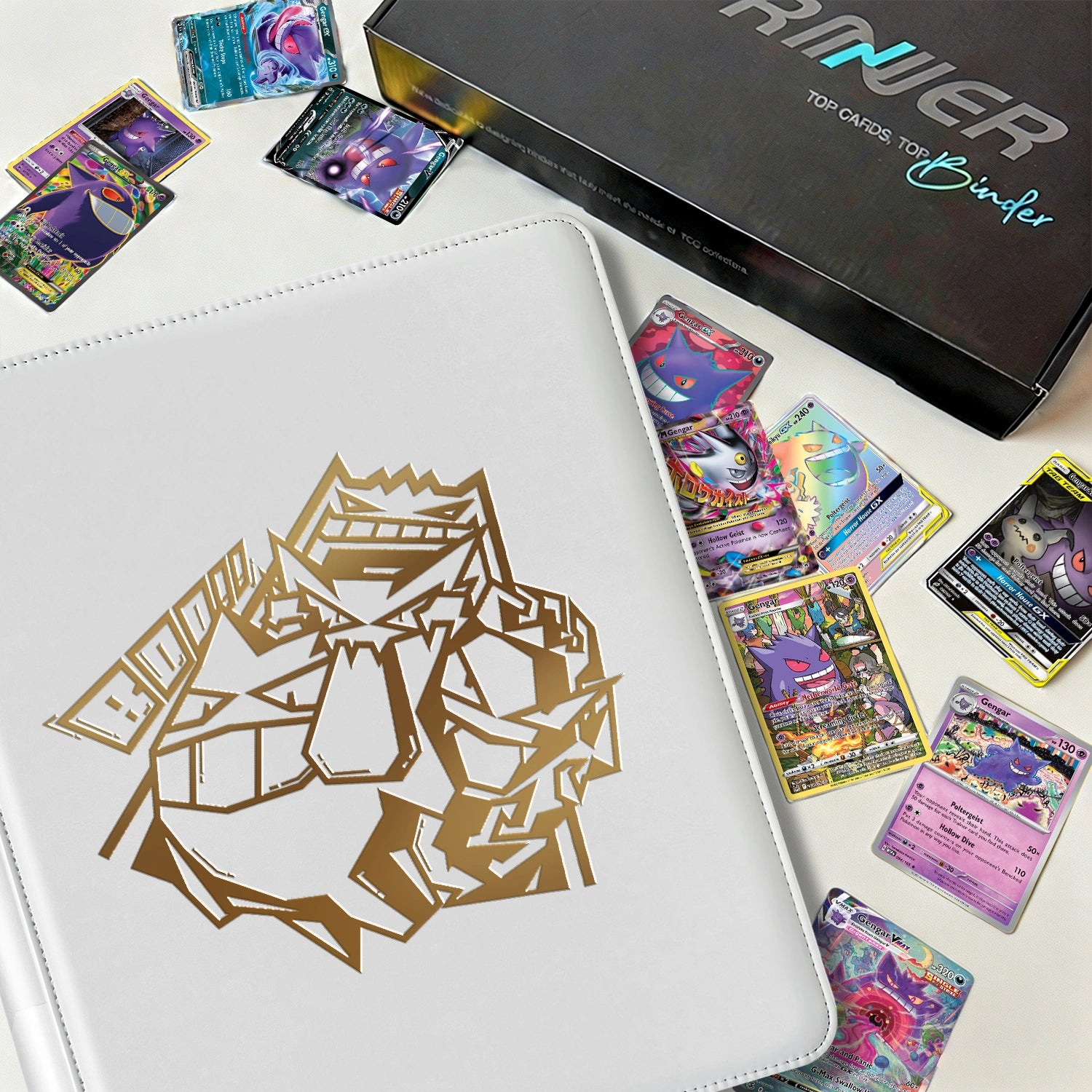 White Pokemon toploader binder displayed beside scattered Gengar holographic cards and a premium gift box
