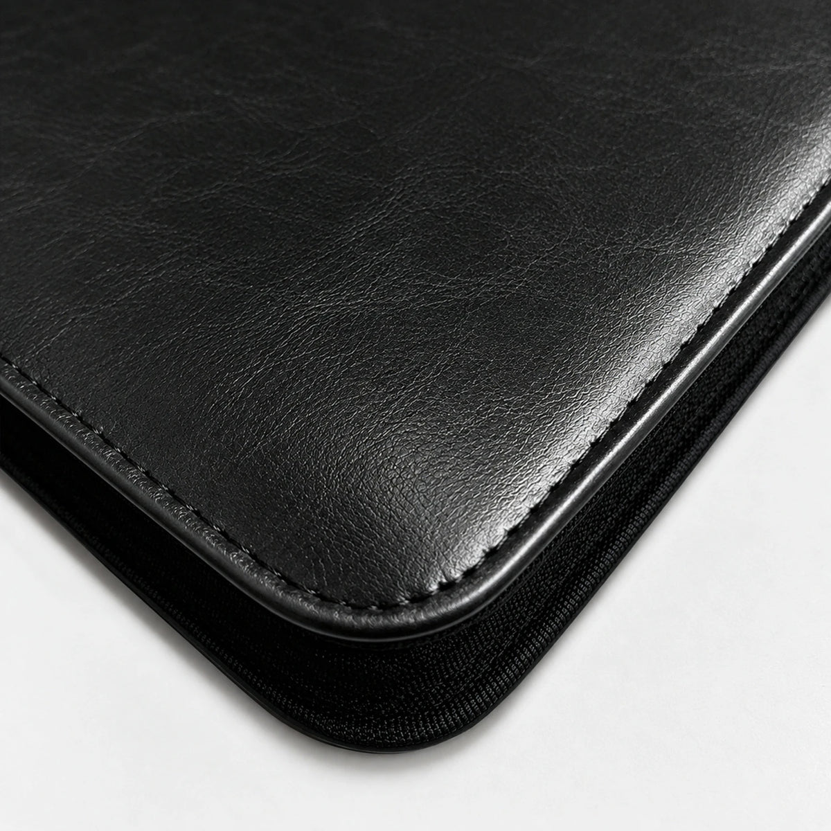 Close-up of black PU leather texture, stitching, and zippered edge