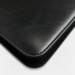 Close-up of black PU leather texture, stitching, and zippered edge