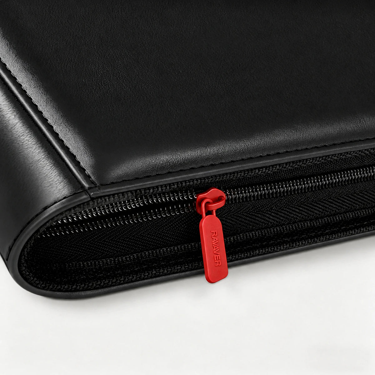 Close-up of a red zipper pull on a black leather card binder